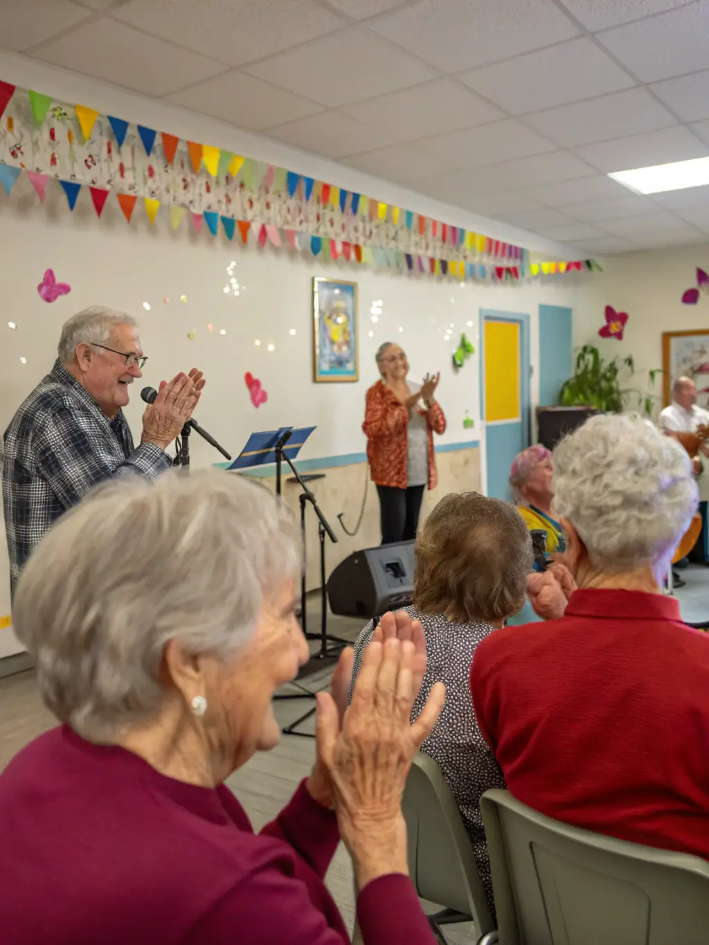 A heartwarming image of a senior citizen music workshop in Saint-Aigulin, showing elderly participants playing percussion instruments, highlighting the therapeutic and social benefits of music.